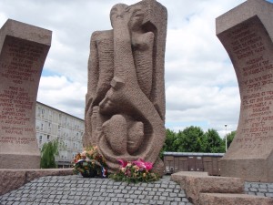 Sculpture with building and railcar in the background
