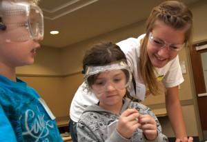 A student works with children at Camp Invention.