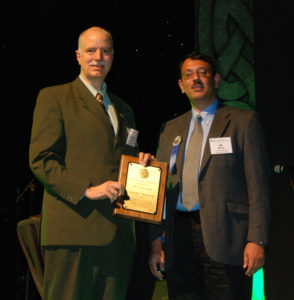 Don Wunsch, left, accepts the International Neural Networks Society's Gabor Award from INNS president Ali Minai during an awards ceremony in Dublin.