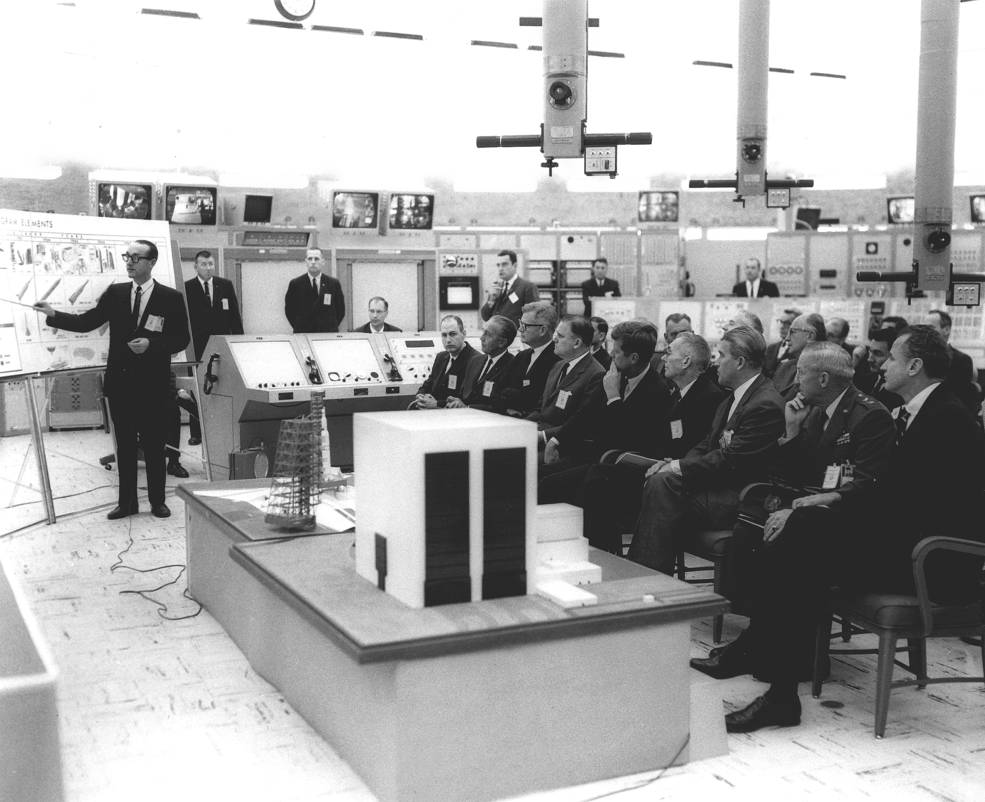 Dr. George Mueller briefs President John F. Kennedy and other officials on the Saturn V rocket. Front row, left to right: George Low, Kurt Debus, Robert Seamans, James Webb, President Kennedy, Hugh Dryden, Wernher von Braun, Gen.l Leighton Davis and Senator George Smathers. Photo credit: NASA