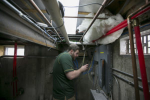 Cory Brennan checks the wiring of the Solar Village Microgrid. Sam O'Keefe/Missouri S&T