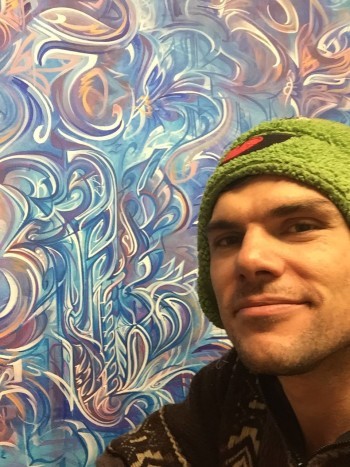 Derek Carpenter poses with a piece of his artwork.