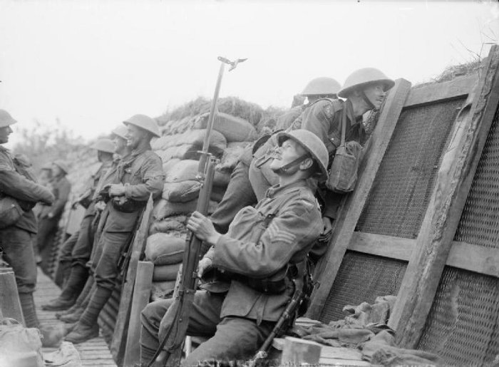 Soldiers wait in a trench during World War I. Public Domain