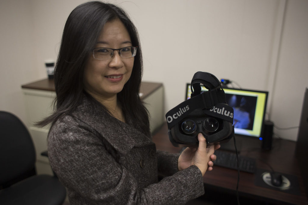 Dr. Fiona Nah, professor of business and information technology, poses with an Oculus Rift virtual reality headset in the Laboratory for Information Technology Evaluation.