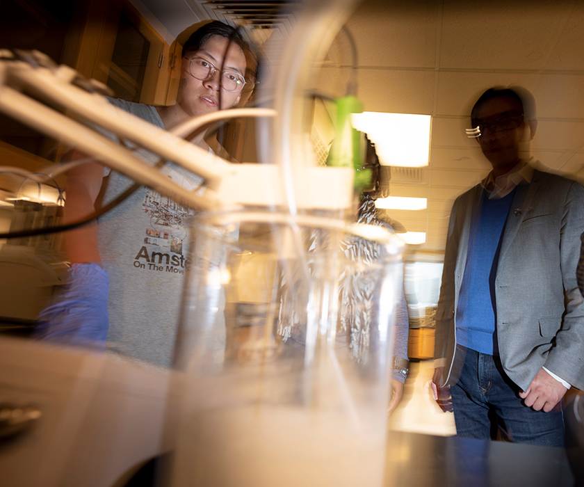 Bowen Tan, a graduate research assistant in civil engineering, adds carbon dioxide to a lime water solution as part of a nanoparticle research project led by Dr. Hongyan Ma (in background), assistant professor of civil engineering. Photo by Tom Wagner/Missouri S&T ©2019 Missouri S&T