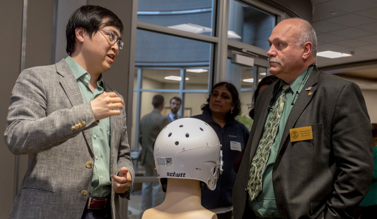Dr. Jie Huang (left) discusses one of his "smart" helmet prototypes with Missouri State Rep. Don Mayhew. Photo by Tom Wagner, Missouri S&T.