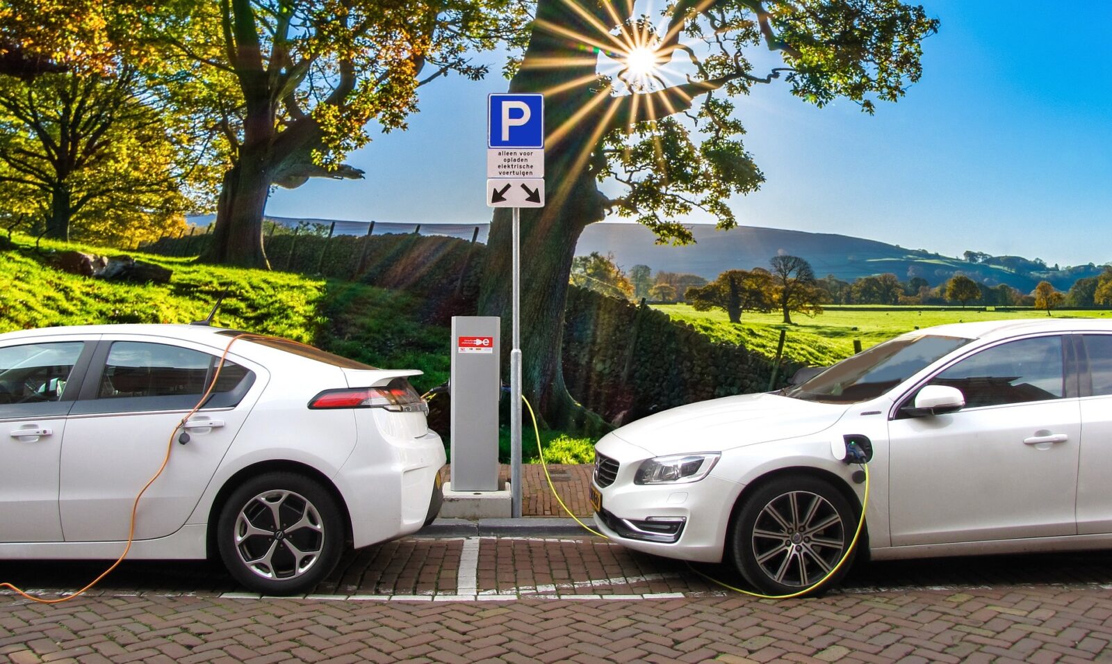 photo of white cars at an electric charging station