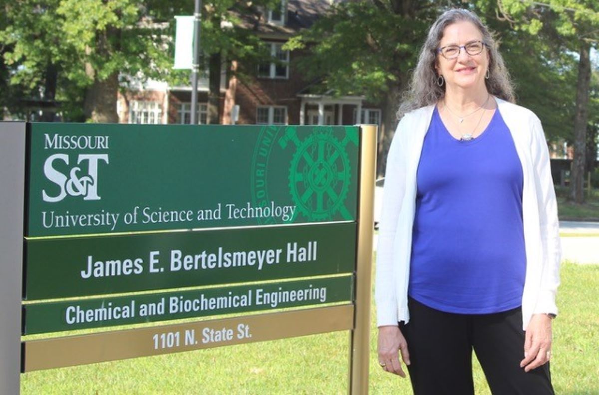 Photo of Dr. Christi Luks standing beside Bertelsemeyer Hall