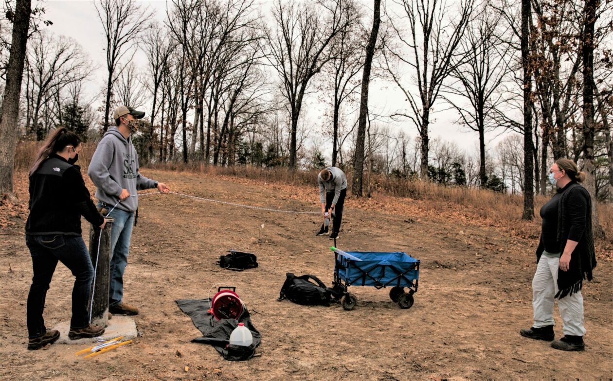 S&T students and their graduate teaching assistant working at groundwater monitoring well