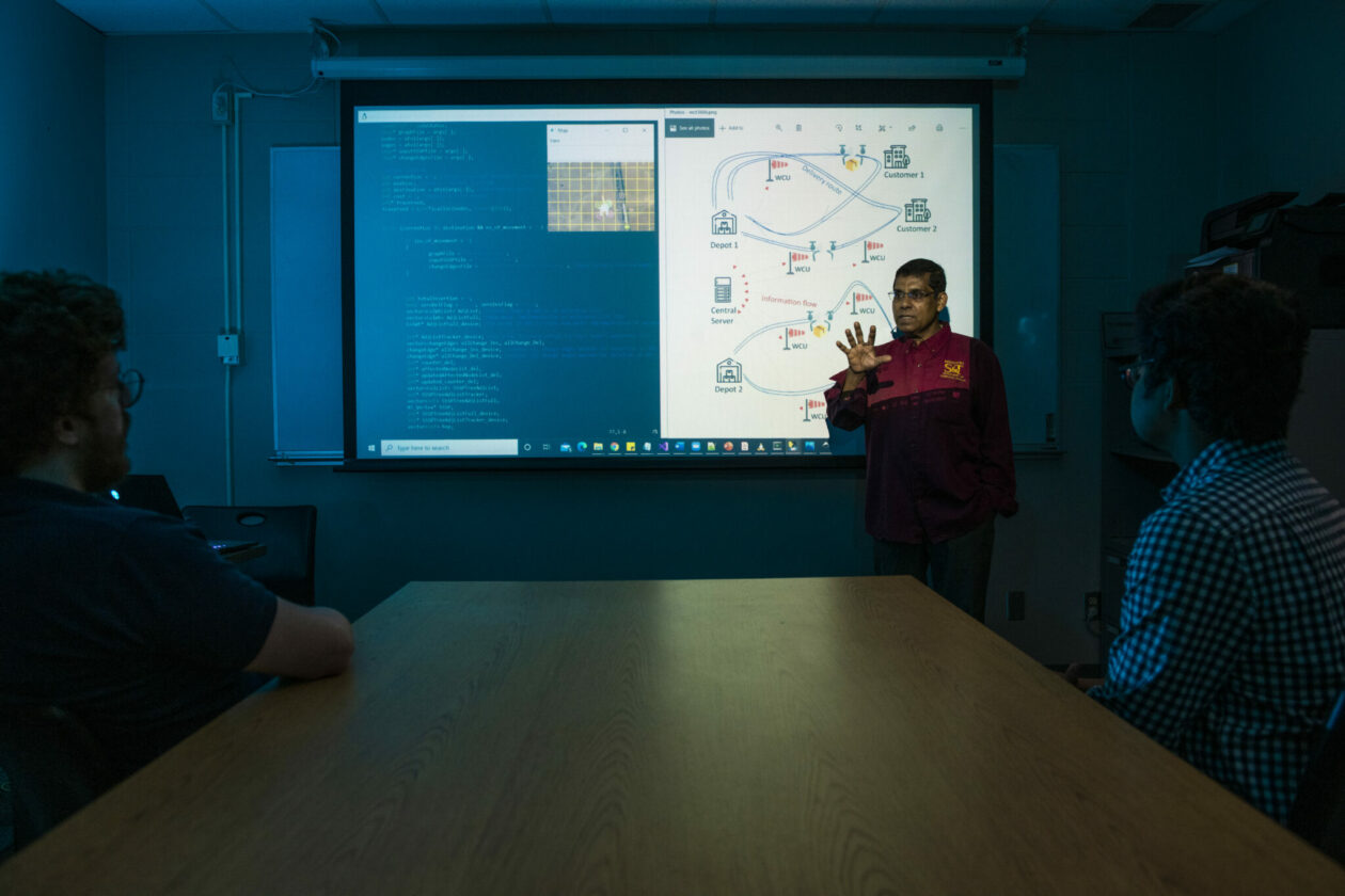 Photo of Dr. Sajal Das with projected image of CANDY project