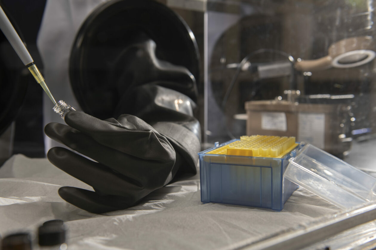 Photo of handling radioactive materials in a box equipped with gloves to protect the worker.