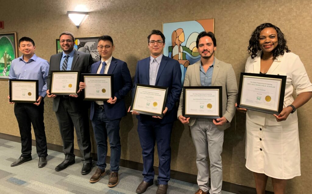 Photo of the three winners of the dean's Ph.D. scholar awards, along with the associate dean of academic affairs.