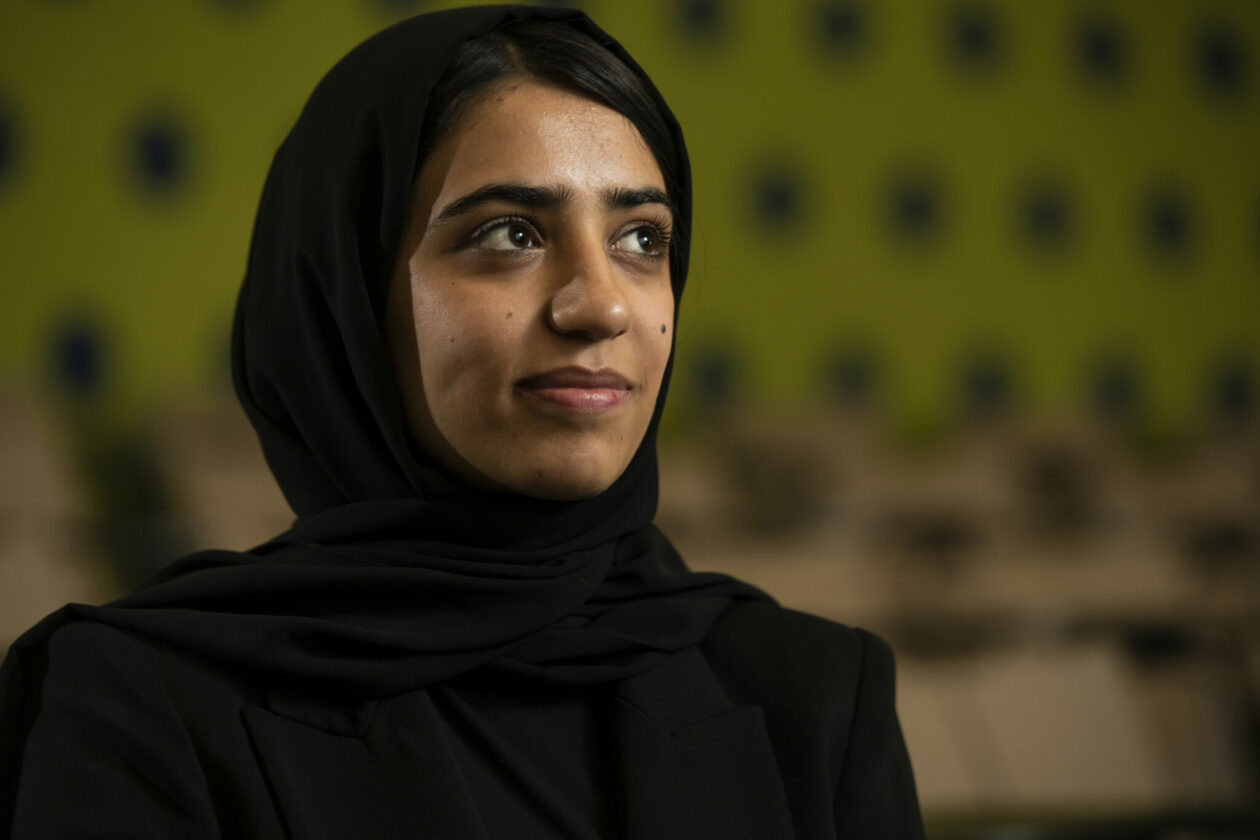 Photo of Somaya Faruqi, who is wearing a black top and black head covering. She is gazing into the distance with a slight smile on her face.