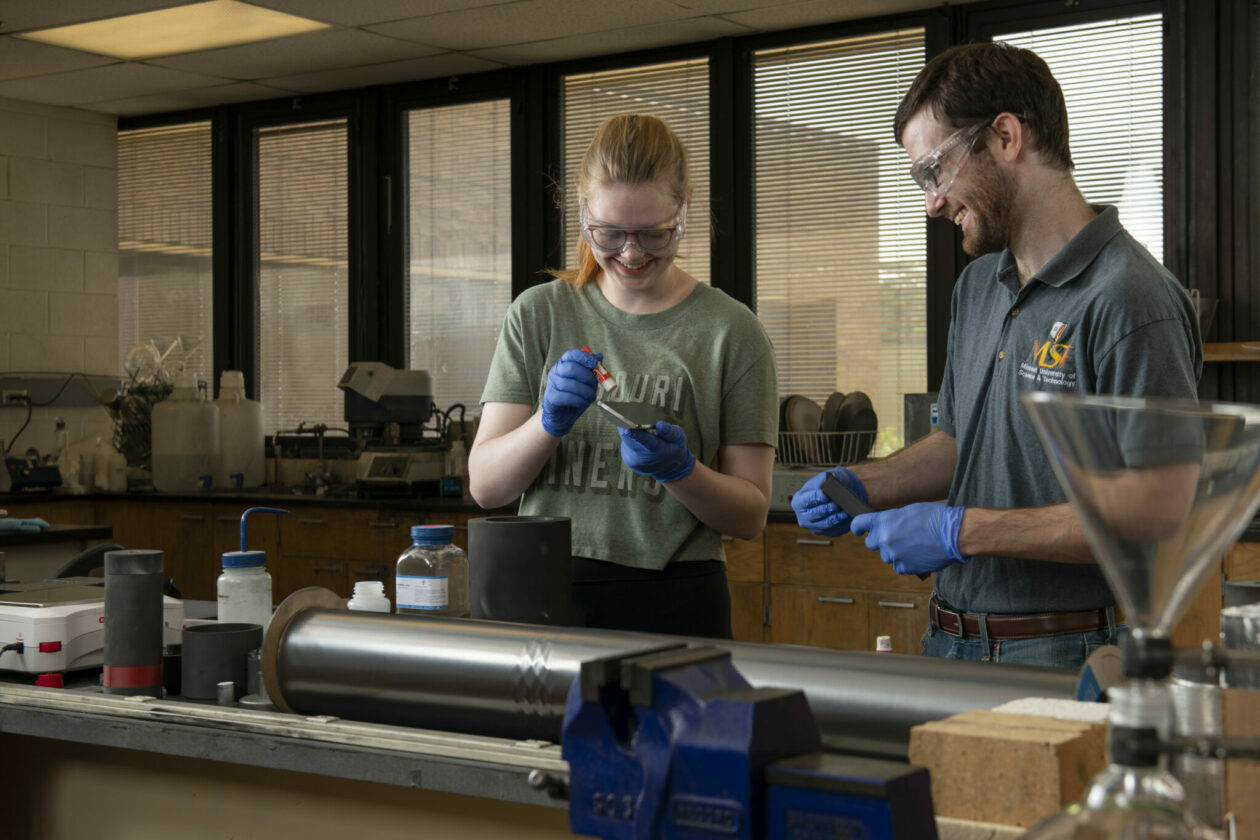 Two students, a woman on the left and a man on the right, work in a ceramic engineering lab.