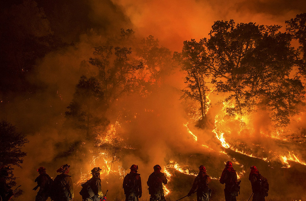 Wild fire with firefighters looking at fire