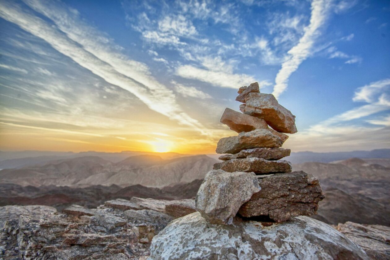 Stacked brown rocks with the sun setting in the distance.