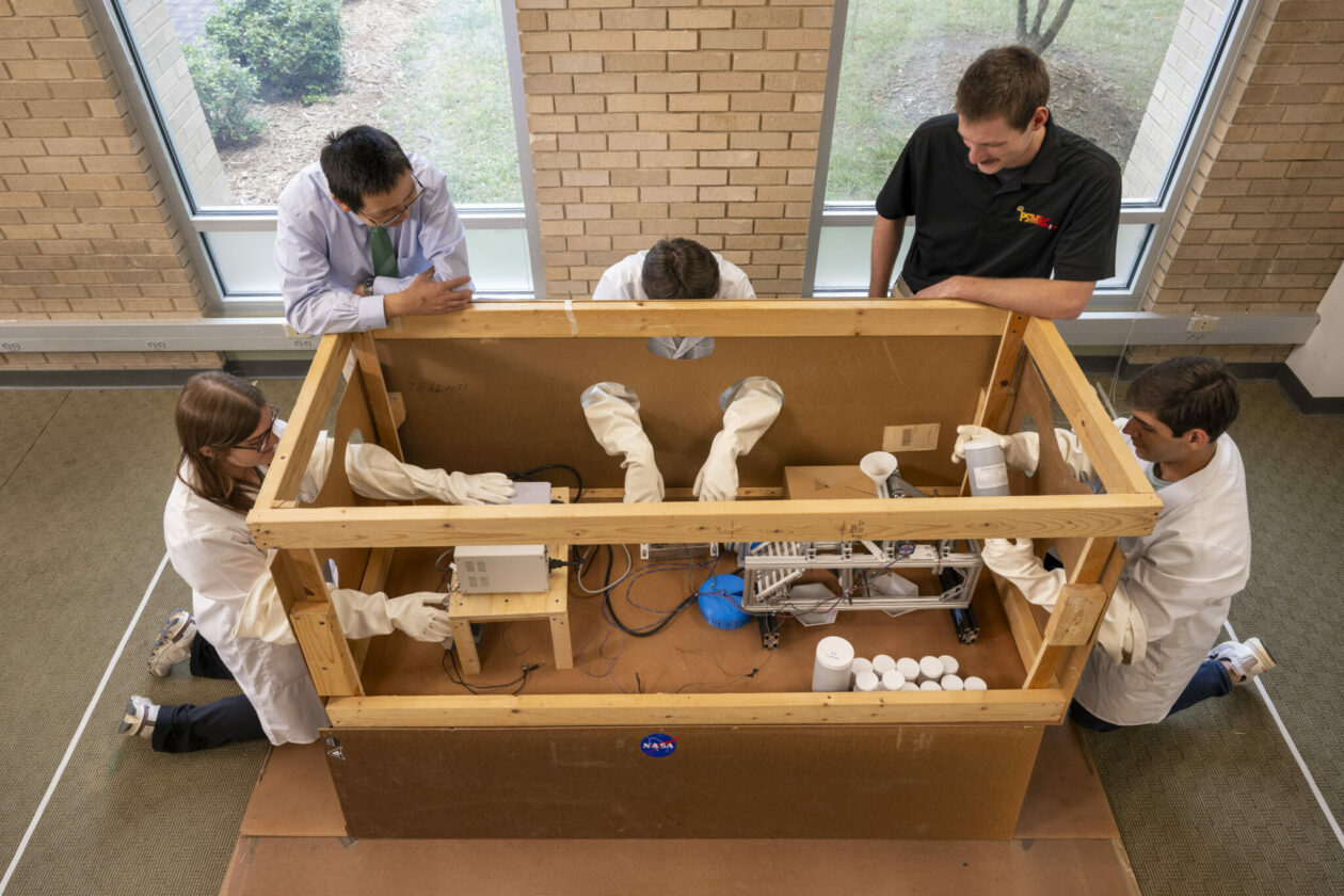 Dr. Daoru Han, second from left, oversees a group of students rehearsing how to test the team’s technology for separating moon regolith materials in lunar gravity conditions. Pictured, from left, are Marissa Verduin, Han, Trey Brown, Charles Wood, and Justin Viers. Photo by Michael Pierce/Missouri S&T.
