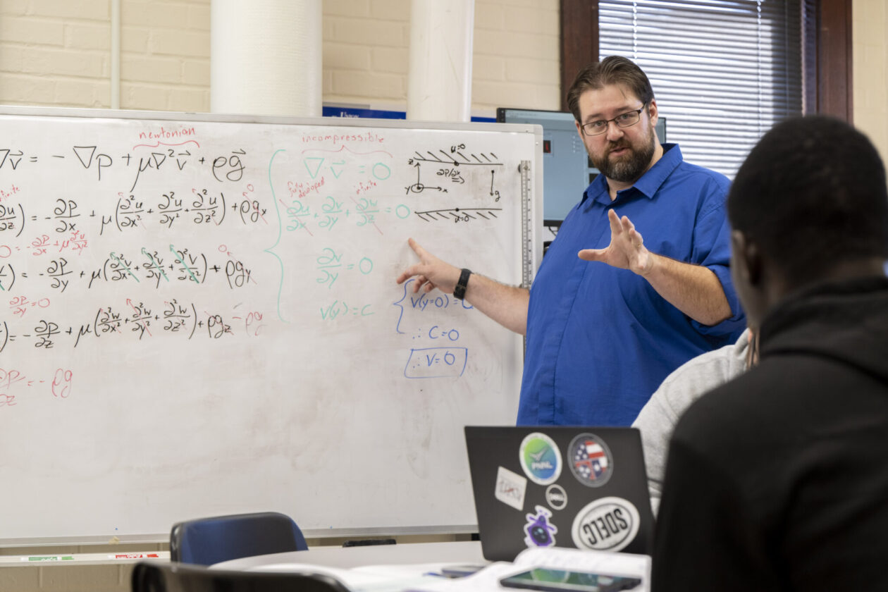 Dr. Joshua Schlegel, an associate professor of nuclear engineering and radiation science at Missouri S&T, works through a problem with his students. Photo by Michael Pierce/Missouri S&T.