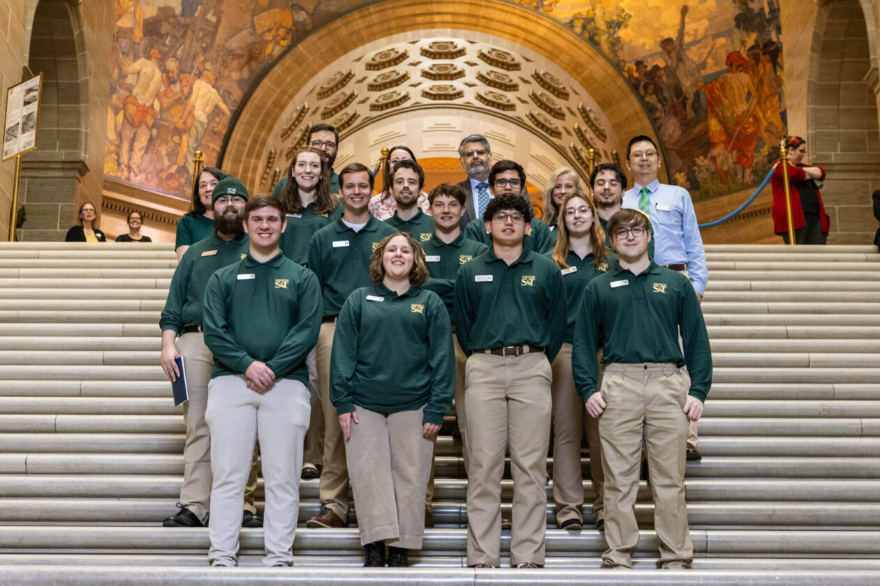Students stand on stairs within Missouri State Captiol