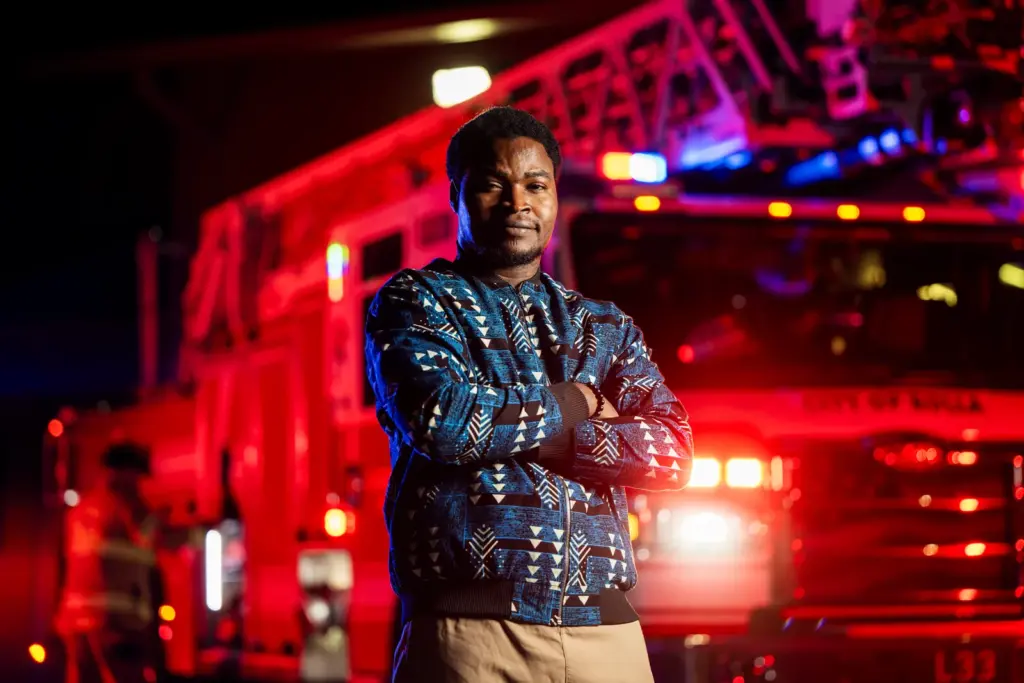 Ademola Adesokan standing in front of fire engine