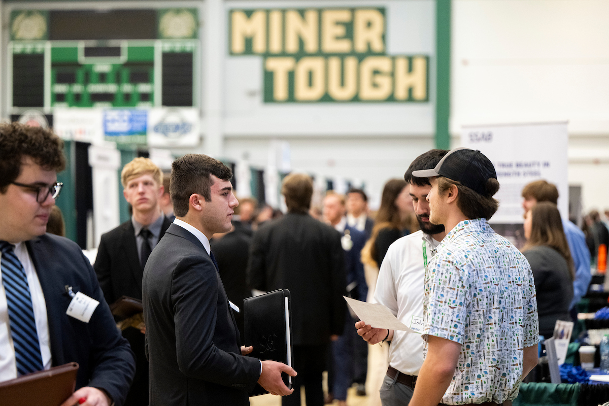 Students and recruiters at the Missouri S&T spring career fair in 2025. In the background, the words "Miner Tough" are visible painted on the wall.